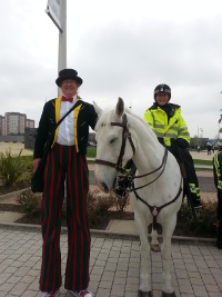 Stilt walking with a police horse